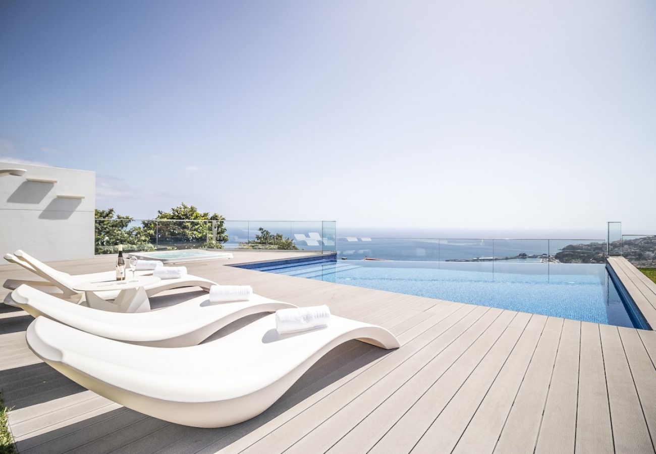 Swimming pool surrounded by a garden with panoramic views of the sea.
