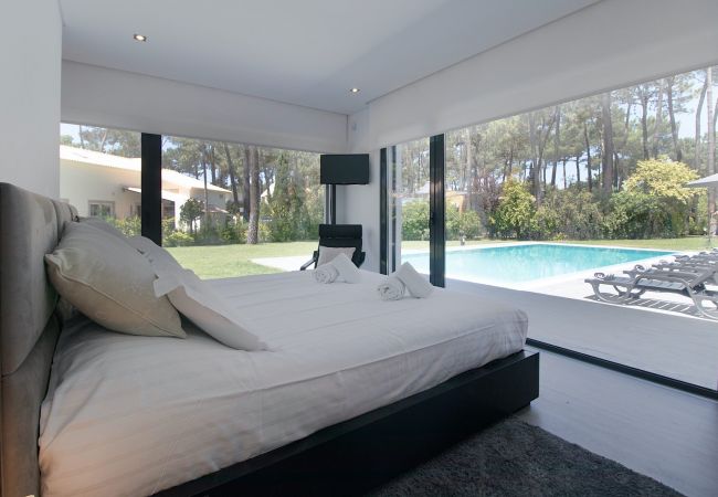 Enjoy a charming room with a view of the spacious garden at Villa Alfazema IV in Aroeira.